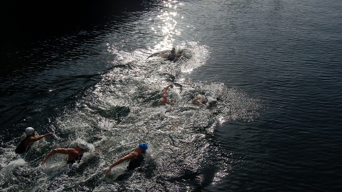 Open water swimmers moving together through a real race course